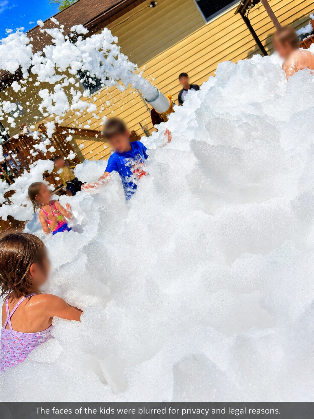 Children playing in foam with bubbles flying overhead